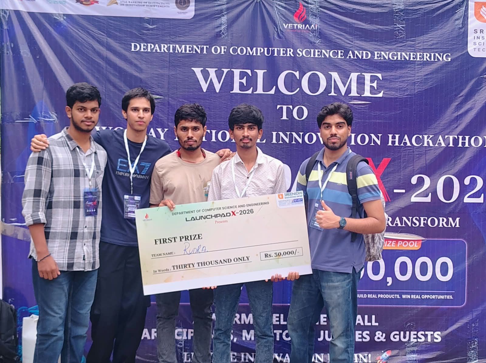 The five members of Team Rudra holding the LaunchPad X 2026 first-prize cheque for Rs. 30,000 in front of the event banner