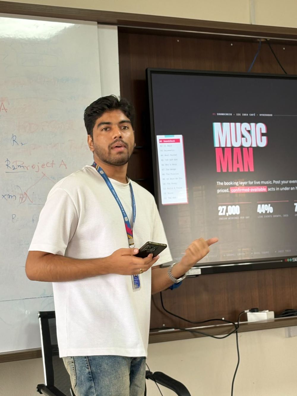 Victor pitching in front of a screen showing the Music Man title slide