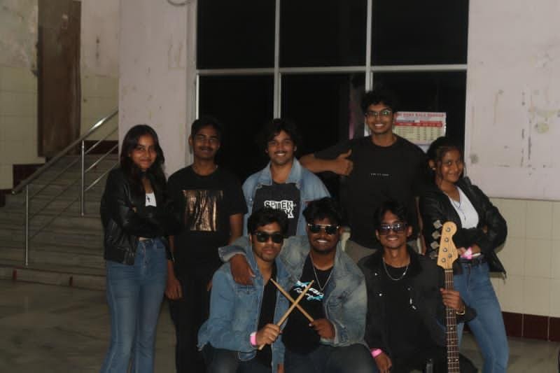Band backstage with drumsticks and a bass guitar